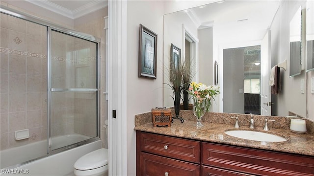 full bathroom with toilet, vanity, ornamental molding, and enclosed tub / shower combo