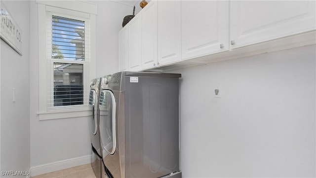 washroom with washer and dryer, baseboards, cabinet space, and light tile patterned flooring