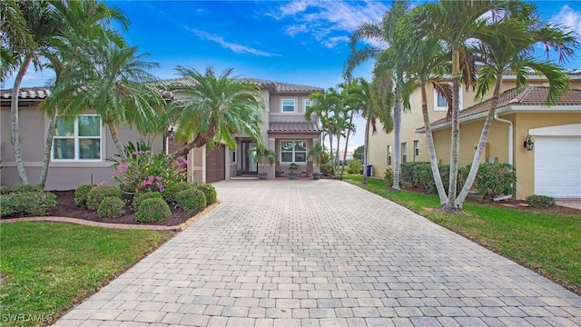 6534 Plantation Preserve Cir N, Fort Myers, FL 33966 - mediterranean / spanish-style house featuring decorative driveway, stucco siding, a tile roof, and a front yard