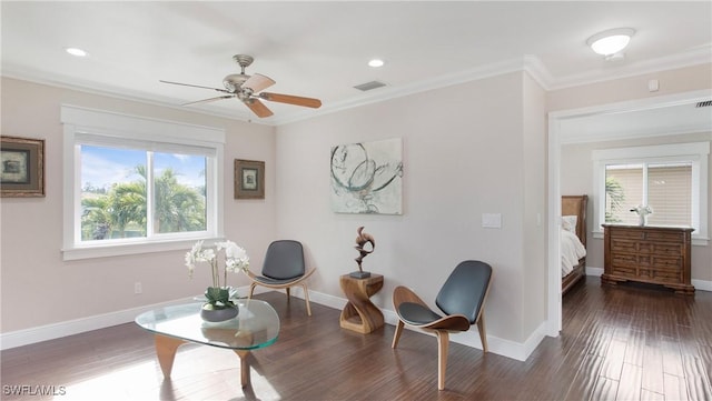 sitting room with visible vents, baseboards, wood finished floors, and ornamental molding