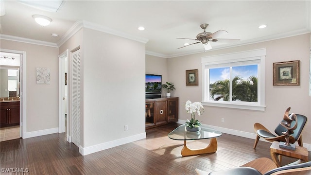 living area featuring baseboards, wood finished floors, ornamental molding, and a ceiling fan
