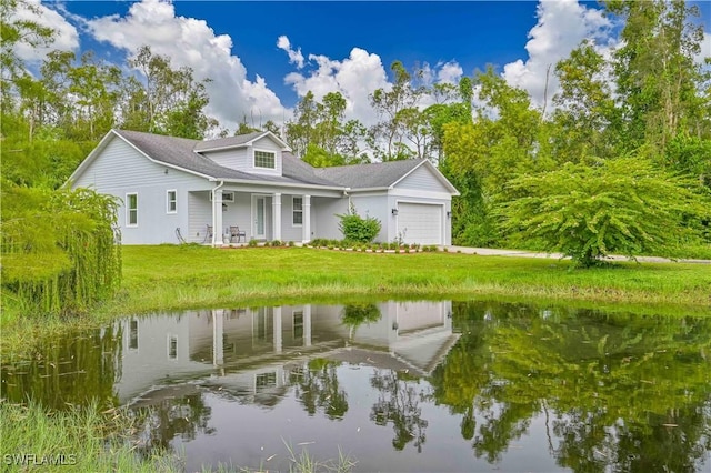 exterior space featuring a water view, a garage, and a lawn