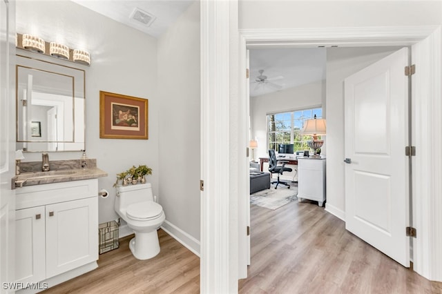 bathroom featuring vanity, ceiling fan, wood-type flooring, and toilet