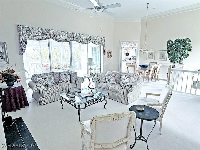 living room with a towering ceiling, ornamental molding, and ceiling fan