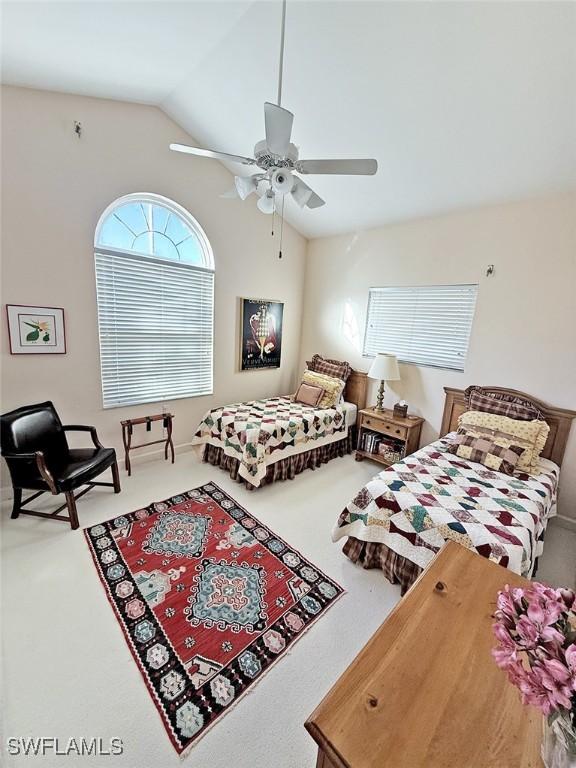 bedroom with vaulted ceiling, ceiling fan, and carpet