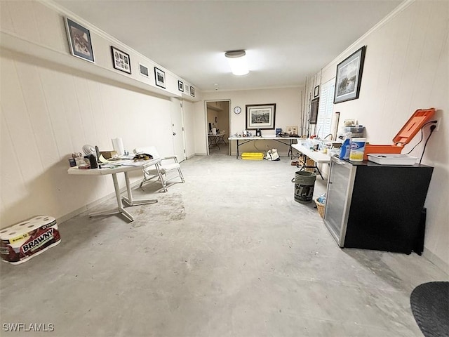 miscellaneous room featuring concrete flooring, ornamental molding, and a workshop area