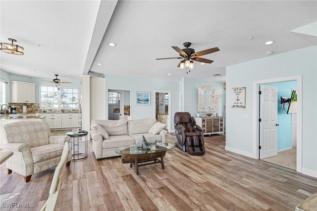 living room with ceiling fan and light wood-type flooring