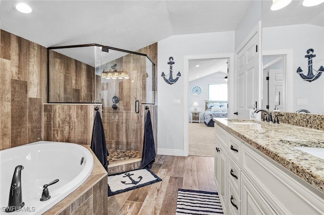 bathroom featuring vanity, lofted ceiling, hardwood / wood-style floors, and separate shower and tub