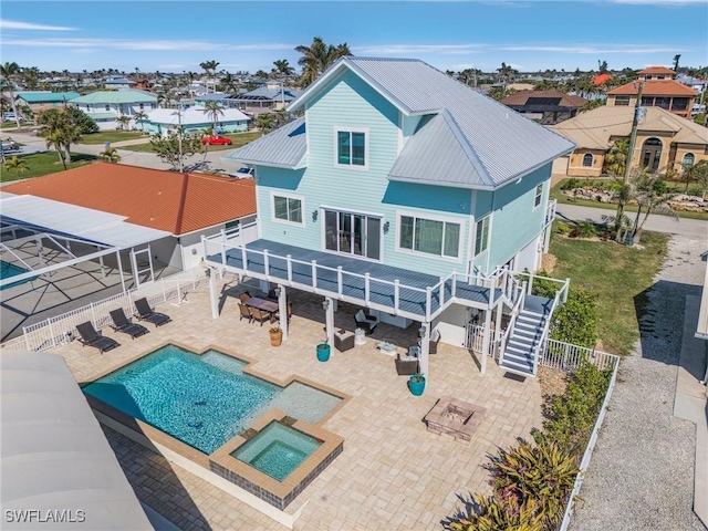 back of property with a pool with hot tub and a patio area