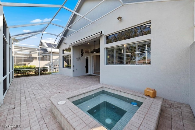 view of swimming pool featuring a patio area, glass enclosure, and an in ground hot tub