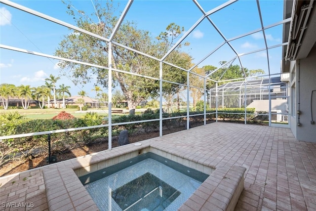 view of pool featuring a lanai, a patio area, and an in ground hot tub