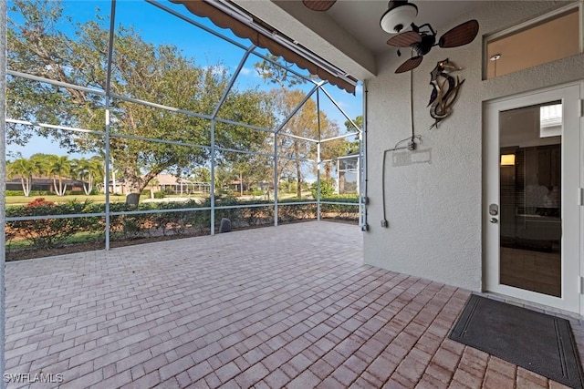 view of patio / terrace with ceiling fan and glass enclosure