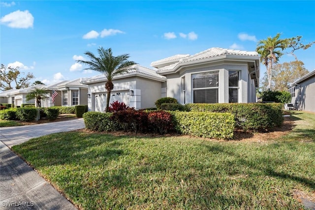 mediterranean / spanish house with a garage and a front lawn