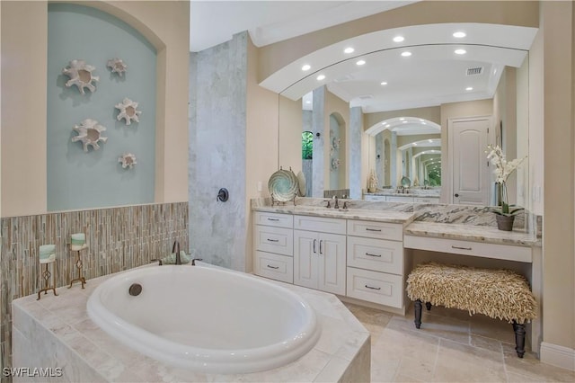 bathroom featuring vanity and tiled bath