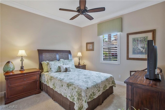 carpeted bedroom with ornamental molding and ceiling fan