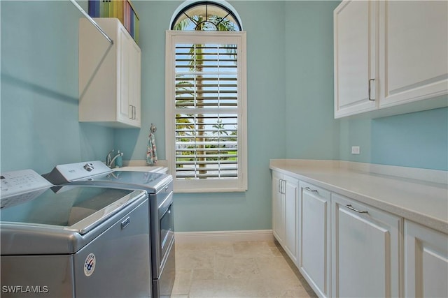 laundry room featuring independent washer and dryer and cabinets