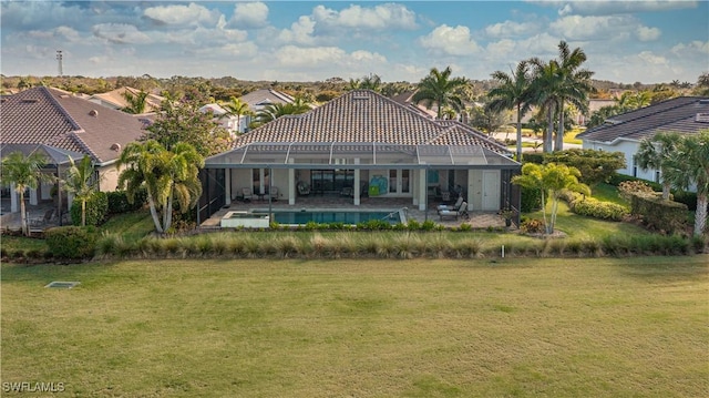 back of property featuring a patio area, glass enclosure, and a lawn