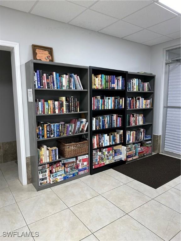 interior space with a drop ceiling and tile patterned floors