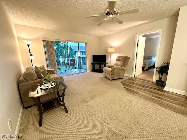 living room with ceiling fan, hardwood / wood-style floors, and a textured ceiling