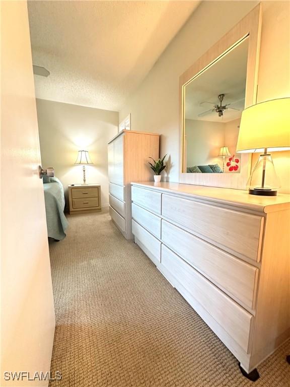 bedroom with light carpet and a textured ceiling