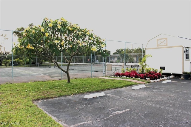 view of sport court with a yard