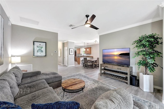 living room featuring crown molding, ceiling fan, and light wood-type flooring