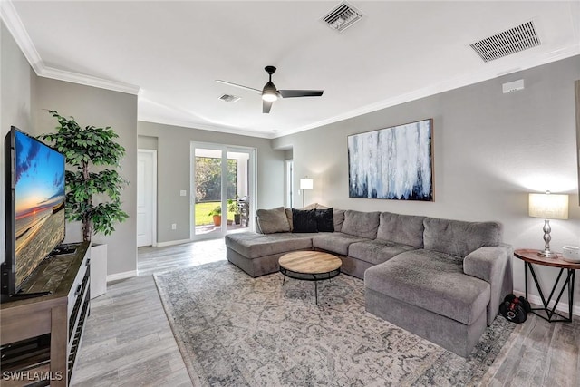 living room with hardwood / wood-style floors, crown molding, and ceiling fan