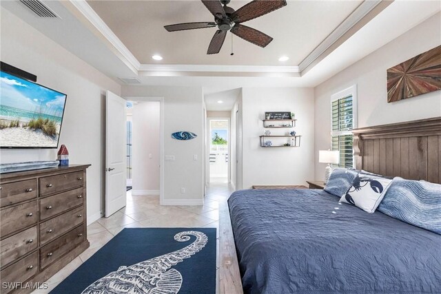 tiled bedroom featuring multiple windows, crown molding, and a tray ceiling