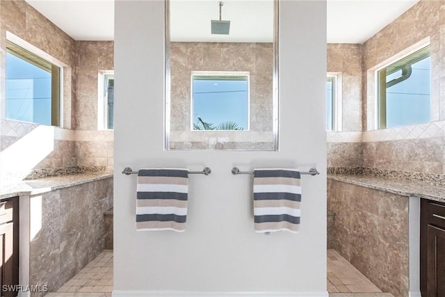 bathroom featuring vanity, a tile shower, and a wealth of natural light