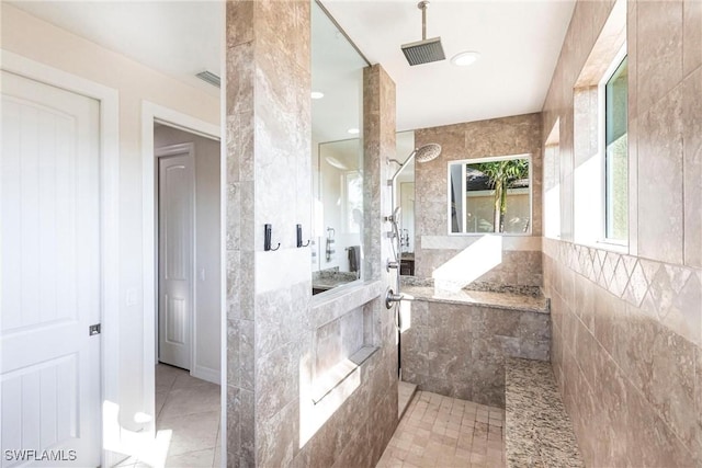 bathroom with a tile shower and tile patterned floors