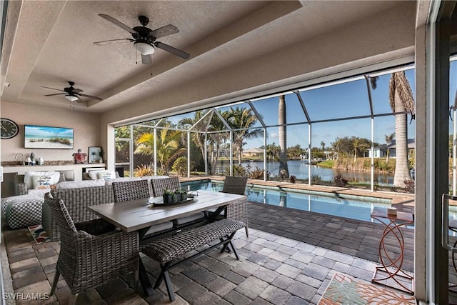 view of patio / terrace with a water view, an outdoor hangout area, ceiling fan, and a lanai