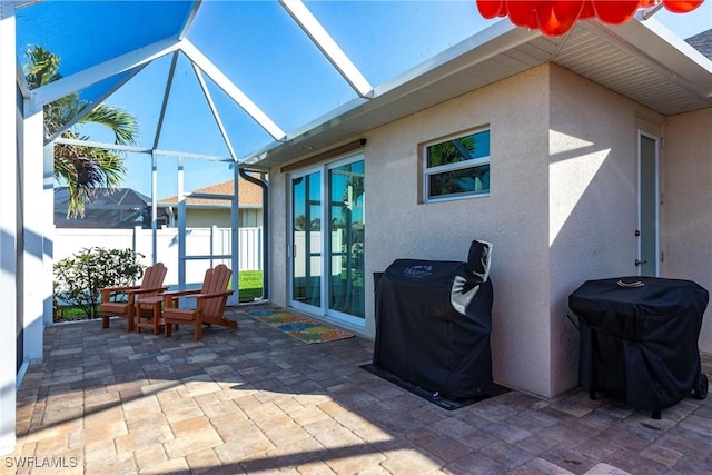 view of patio featuring grilling area and glass enclosure