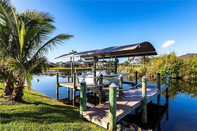 view of dock with a water view and a yard