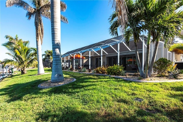 exterior space with a lanai and a lawn