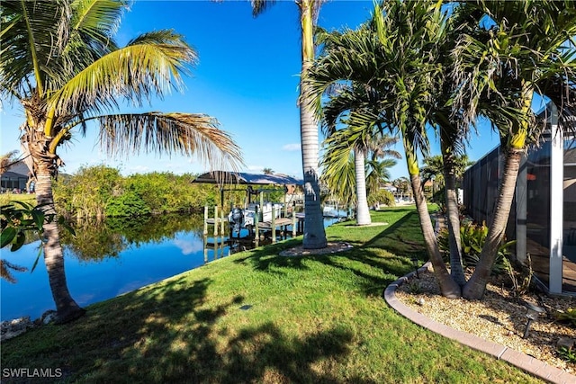 view of dock featuring a lawn and a water view