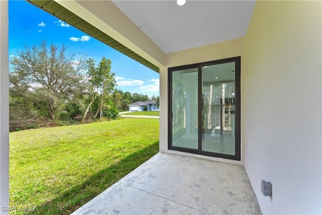 property entrance with a patio area and a lawn