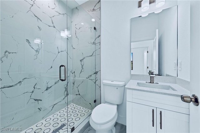 bathroom with vanity, a shower with shower door, and toilet