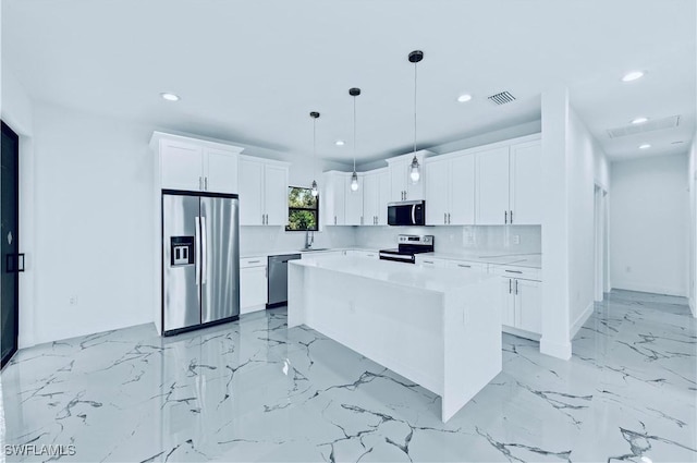 kitchen with white cabinetry, tasteful backsplash, a center island, appliances with stainless steel finishes, and pendant lighting