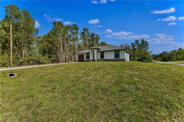 view of front of home with a garage and a front lawn