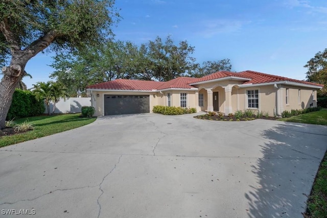 mediterranean / spanish-style house with a garage and a front yard