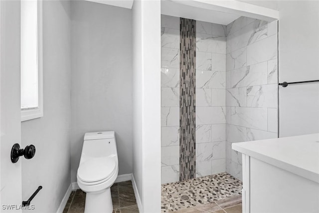 bathroom featuring tiled shower and toilet