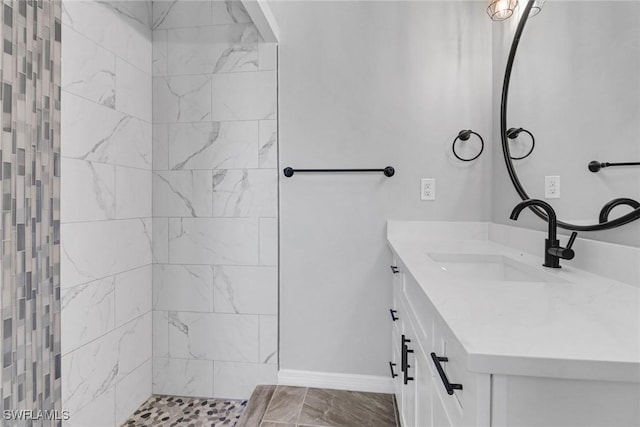 bathroom with vanity and tiled shower