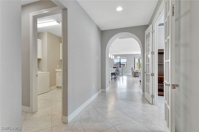 hallway featuring light tile patterned floors and washer / dryer