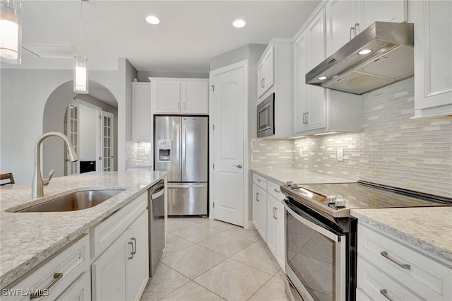 kitchen with sink, white cabinetry, stainless steel appliances, light stone countertops, and decorative light fixtures