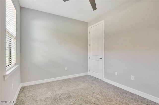 spare room with ceiling fan and carpet