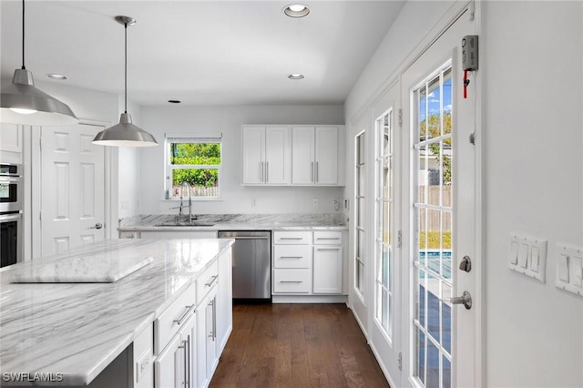 kitchen featuring hanging light fixtures, white cabinetry, appliances with stainless steel finishes, and light stone countertops