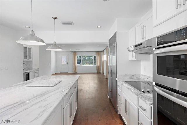 kitchen featuring stainless steel appliances, light stone countertops, dark wood-type flooring, and white cabinets