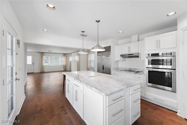 kitchen featuring pendant lighting, white cabinets, dark hardwood / wood-style flooring, a center island, and stainless steel appliances