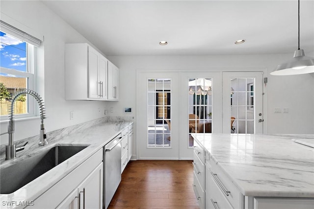 kitchen with sink, white cabinetry, hanging light fixtures, light stone counters, and stainless steel dishwasher