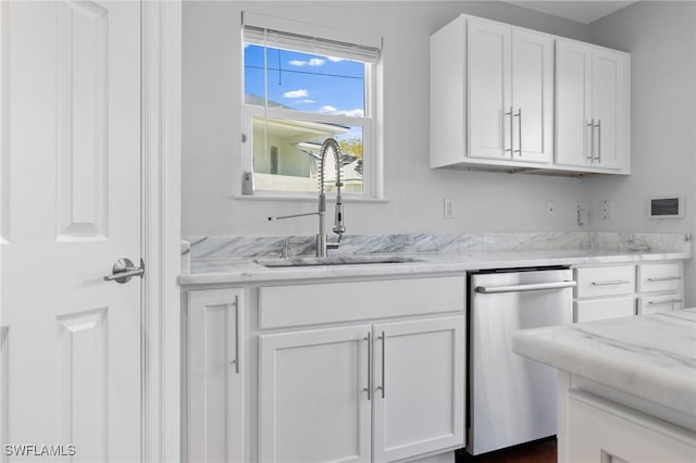 kitchen with white cabinetry, sink, stainless steel dishwasher, and light stone countertops